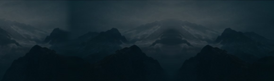 Dark mountain ridges under a low sky
